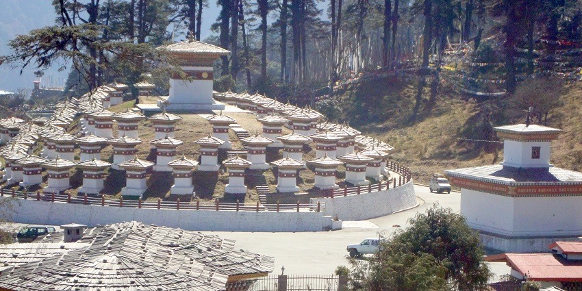 Dochula Pass offering panoramic Himalayan views and 108 chortens amidst lush scenery.
