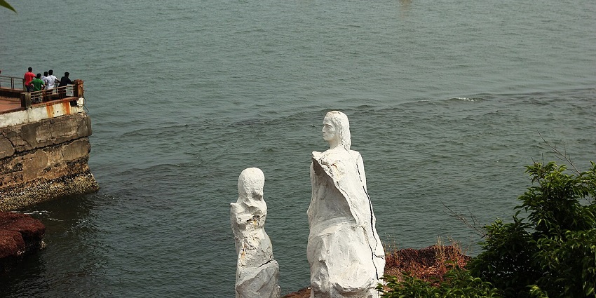 A mesmerising view of a beach with a white statue on the side during the daytime.