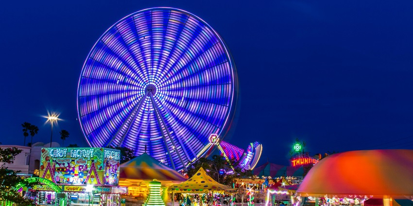 A picture of an amusement park in Bangkok with rides illuminated during nighttime