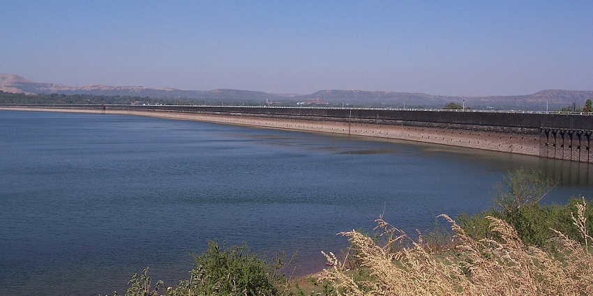 An amazing view of Khadakwasla Dam with lush green surroundings during the daytime.