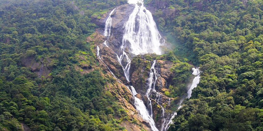 Breathtaking view of Dudhsagar Waterfalls cascading down lush green cliffs