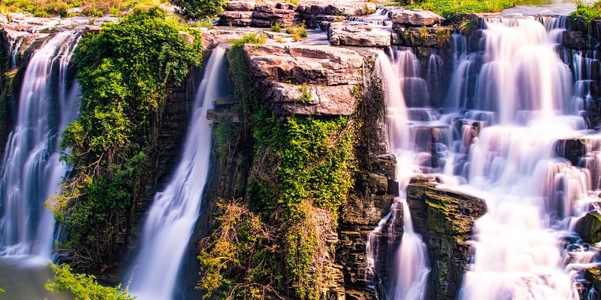 A frontal view of a beautiful landscape with a water body and lush foests
