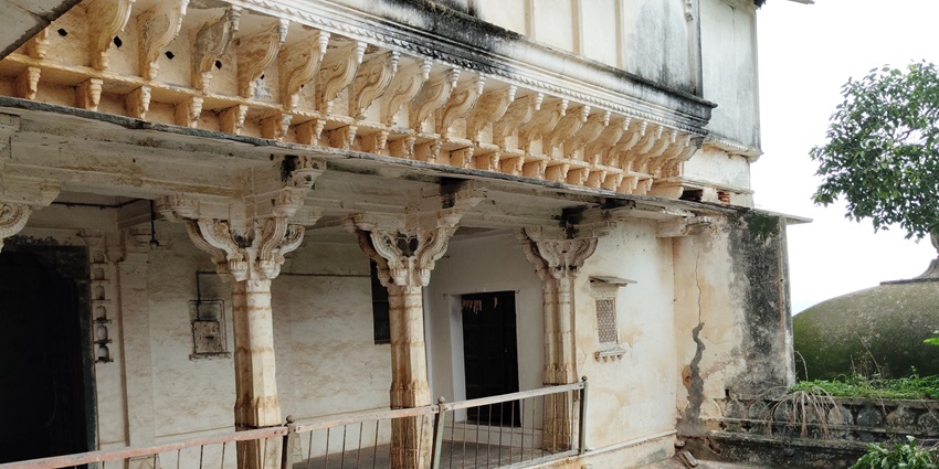 A glimpse of Juna Mahal with marble arches and domes mirrored in the still waters surrounded by greenery.