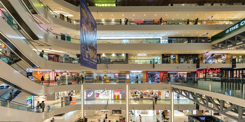 A picture of the interiors of a luxury shopping mall with numerous brand stores visible