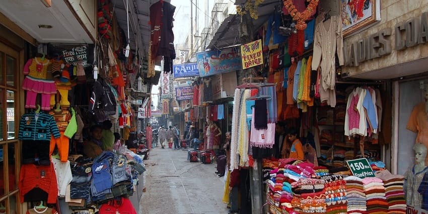 Shops displaying clothes in the narrow streets of the market with shoppers wandering around
