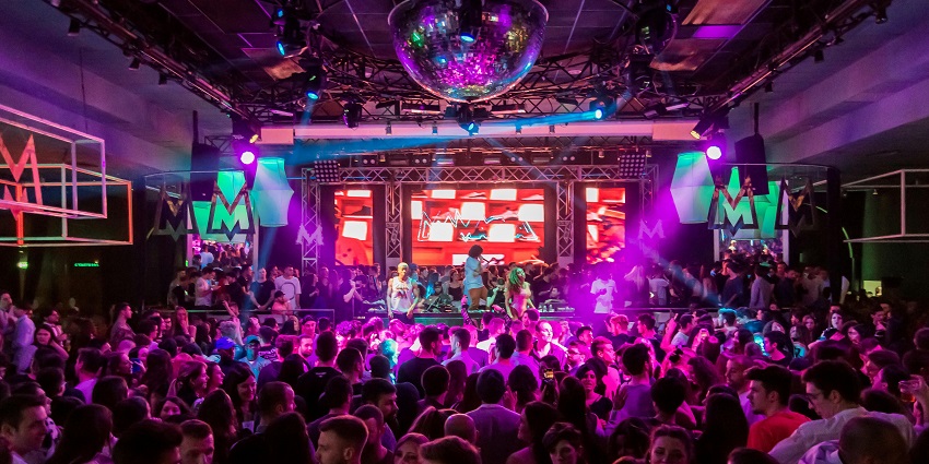 A picture of a vibrant nightclub in Bangkok with an energetic stage performance going on