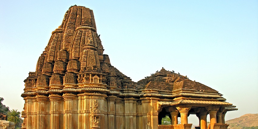 Intricately carved stone pillars and a large courtyard at the Eklingji Temple complex.