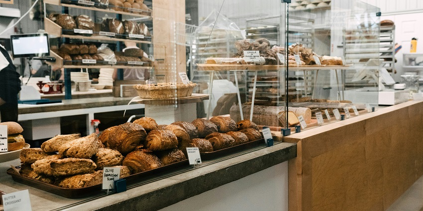 Image of a bakery shop - buns, cakes and more displayed in front of the counter