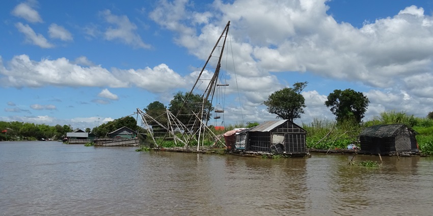 A picture of the Sangker River with huts and fish nets visible on the river banks