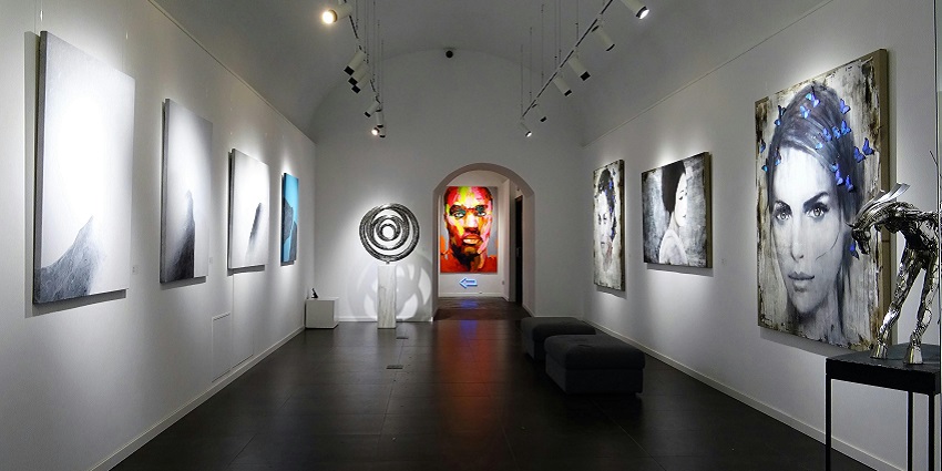 An inside view of a modern art exhibition in Maharashtra featuring colourful paintings.