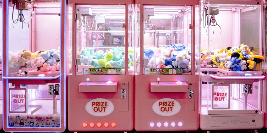 Image of pink colour claw machines displayed in a line for kids and teenagers to play