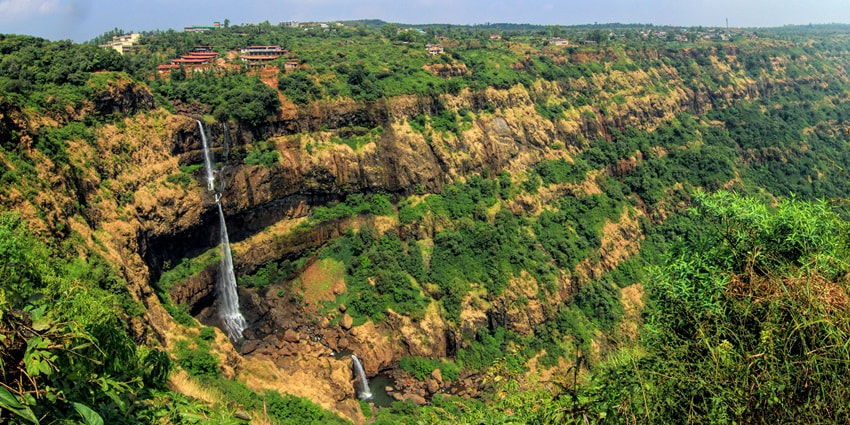 Scenic view of Lingmala Waterfall, showcasing cascading water surrounded by lush greenery.