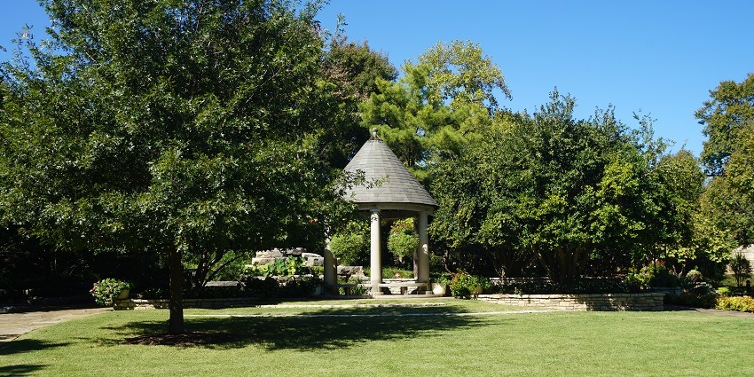 A picture of a beautiful green garden near the famous historical building