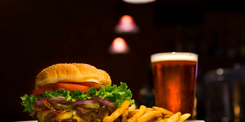 A delicious burger with lettuce and tomato, accompanied by golden fries on a white plate