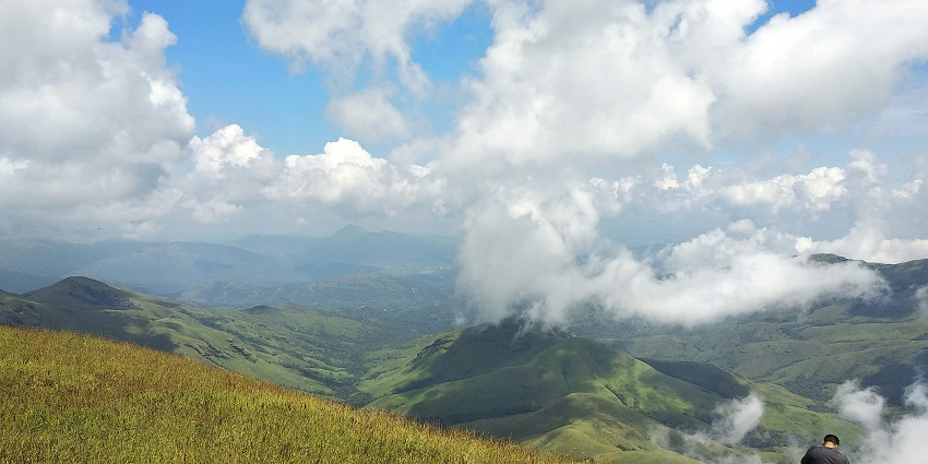 An image of Ettina Bhuja with verdant trees and picturesque vistas encircle the peak.