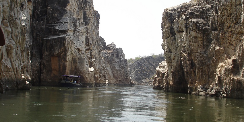 An image of a boat navigating through the majestic marble rocks of Bhedaghat.