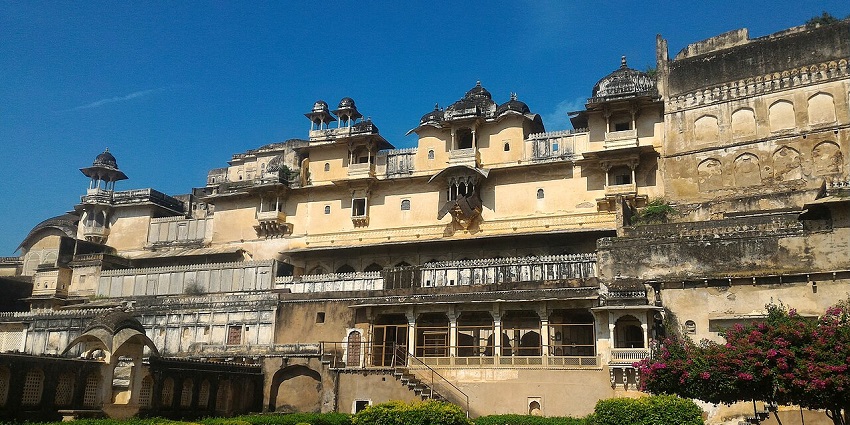 View of the Garh palace surrounded by verdant gardens and floral beauty.