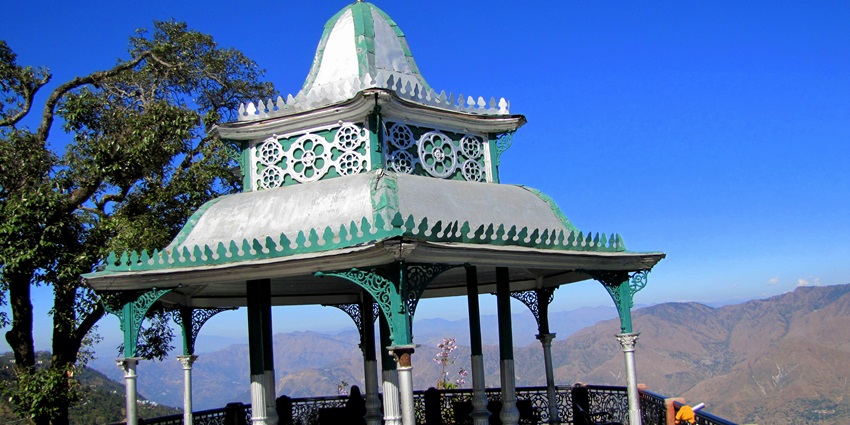 A picture of the Hawa Ghar located on top of a hill, with scenic views of the mountains
