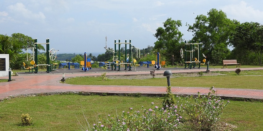 Image of a beautiful park surrounded by lush green landscape under a sunny sky