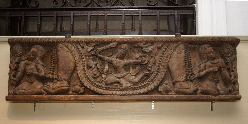 Low-hanging horizontal wooden sculptures signifying religious deities on display here.