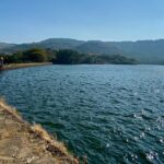 A glimpse of Lonavala, Maharashtra, featuring a quiet street lined with water body.