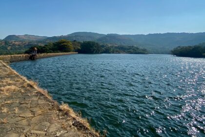 A glimpse of Lonavala, Maharashtra, featuring a quiet street lined with water body.