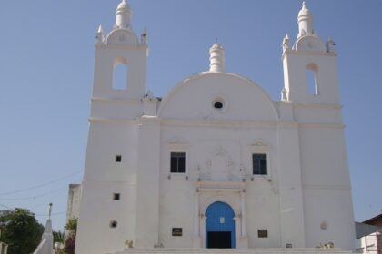 A shining white exterior view of St. Thomas Church with a museum on its premises.