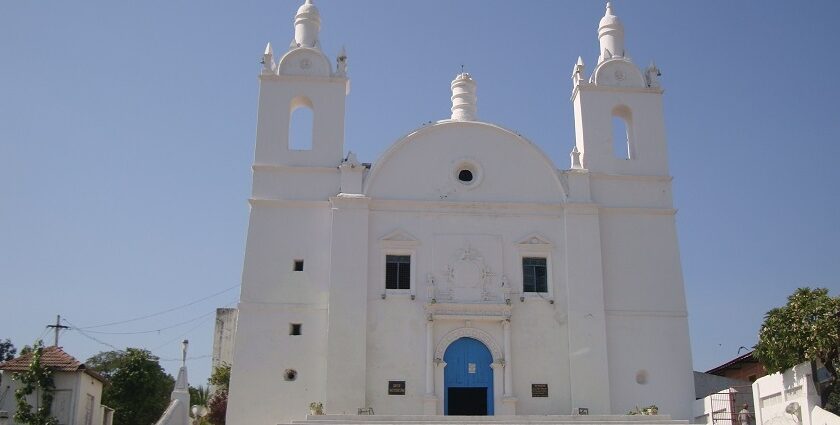 A shining white exterior view of St. Thomas Church with a museum on its premises.