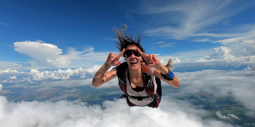 A woman posing for a picture in between her fall in the sky