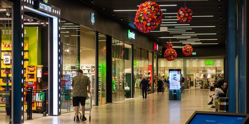 A picture of a man walking past a grocery store at the Eyeplex Mall in Kathmandu