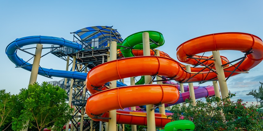 Image of a waterpark with slide spiral pipeline under clear blue sky during day time