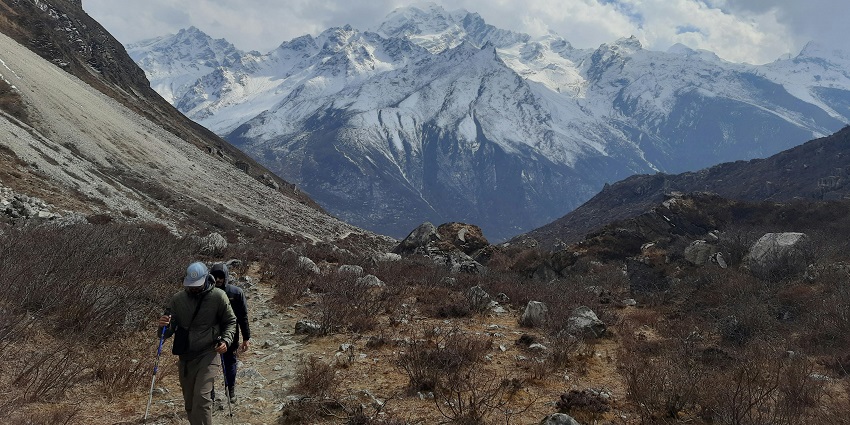 Hiker in diverse terrain, showcasing factors affecting famous adventure sports in Nepal.