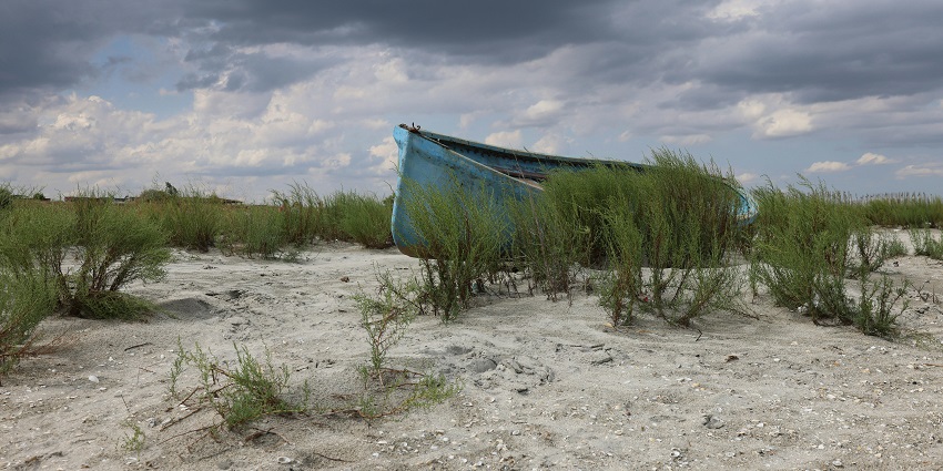 Image of abandoned boat on a stormy seashore - weather conditions that affect scuba diving in Goa Baga Beach
