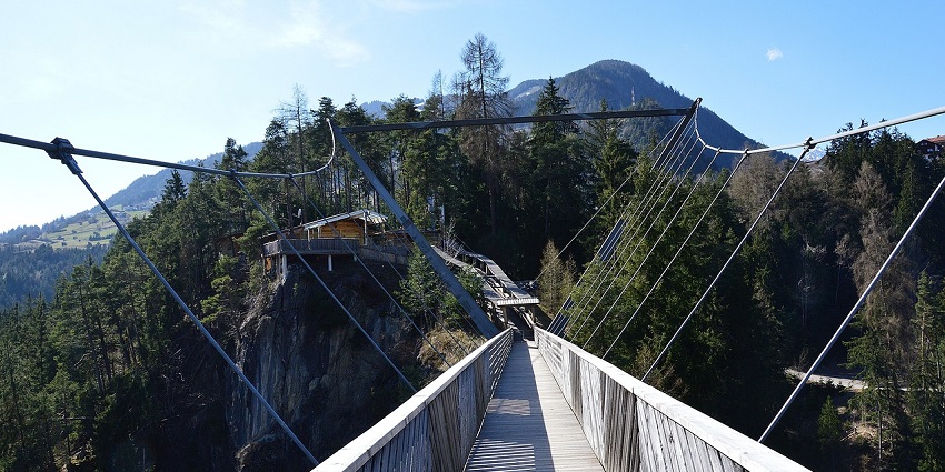 View of a bungee jumping bridge surrounded by lush greenery on all sides