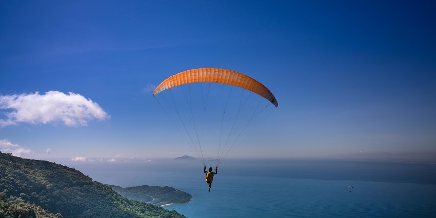 A person enjoying paragliding in Nepal while soaring through the stunning valleys.