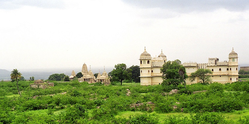 The Fateh Prakash Palace is seen from a distance surrounded by greenery.