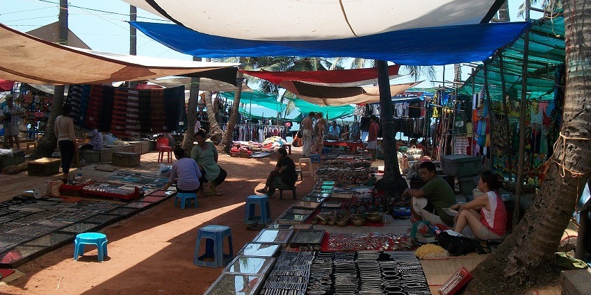 Colourful stalls at Anjuna Flea Market, showcasing vibrant goods and lively atmosphere.