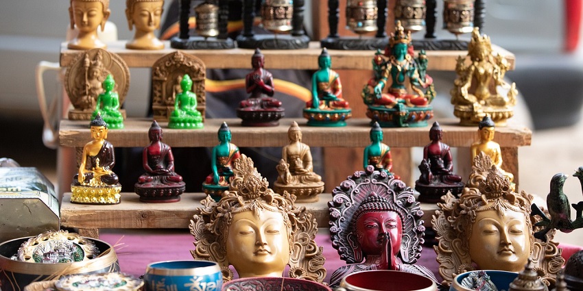Row of golden Buddha statues in Bhutan, surrounded by greenery, symbolising peace and serenity