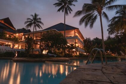 Palm trees illuminated at night, creating a serene tropical atmosphere during the nighttime, similar to the ambience in Forsyth Lodge, Satpura National Park.