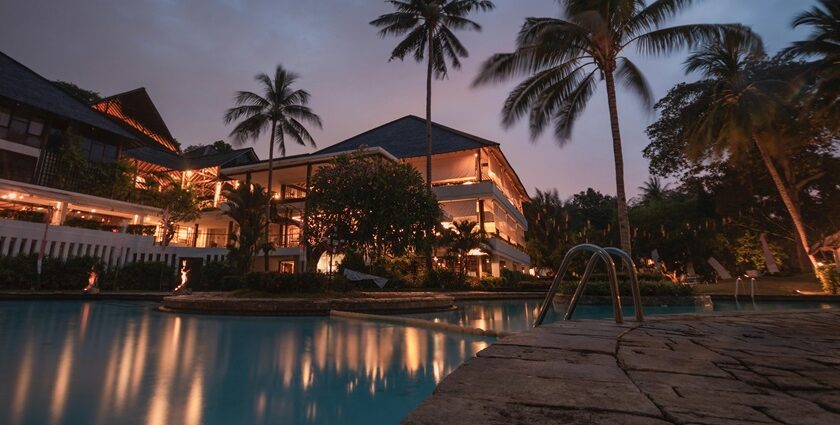 Palm trees illuminated at night, creating a serene tropical atmosphere during the nighttime, similar to the ambience in Forsyth Lodge, Satpura National Park.