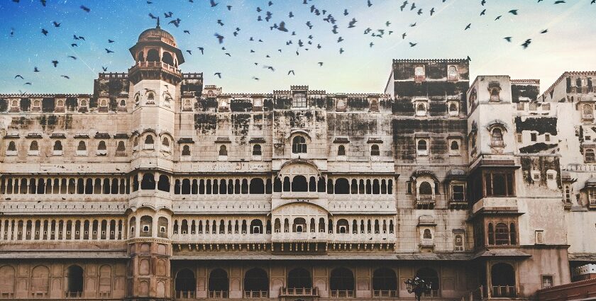 A glimpse of a majestic fort standing against a picturesque backdrop with flying birds.