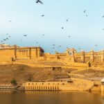 A breathtaking vista of a herd of birds flying over a tourist attraction in the region.