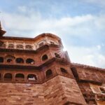 A low-angle view of the iconic tourist attraction of Rajasthan adorned with red shades.