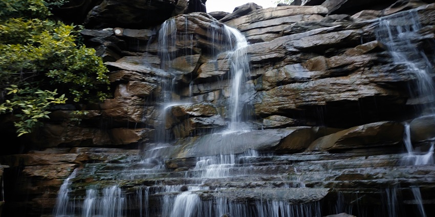 A view of the Gaipernath Waterfall descending from a height, surrounded by greenery.