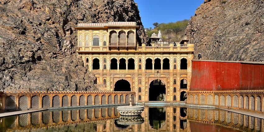 View of the beautiful Galtaji temple, with a tranquil lake in the front and Aravalli ranges in background