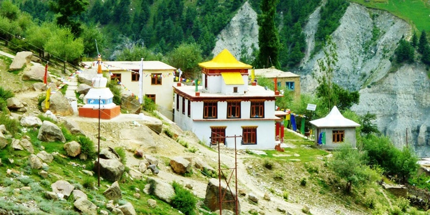 An aerial view of the Gandhola Monastery surrounded by lush greenery in Himachal.