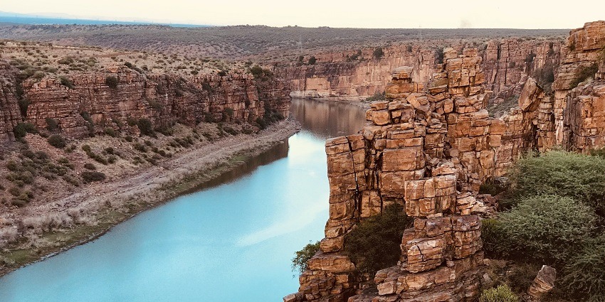 A breathtaking view of a small stream of water flowing through enormous rocky structures. 