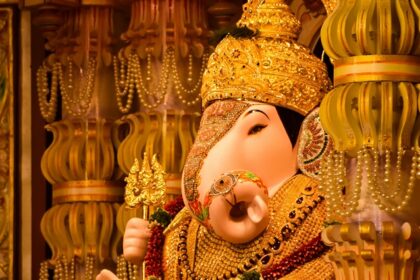 A picture of a temple's interior with decorated pillars and an idol of Lord Ganesha