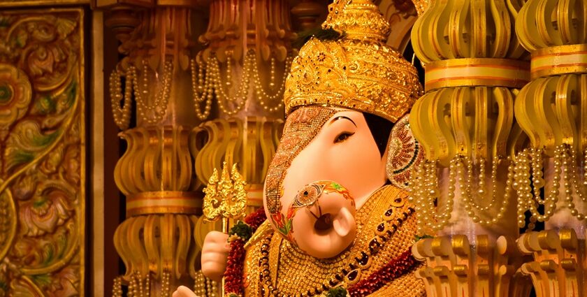 A picture of a temple's interior with decorated pillars and an idol of Lord Ganesha