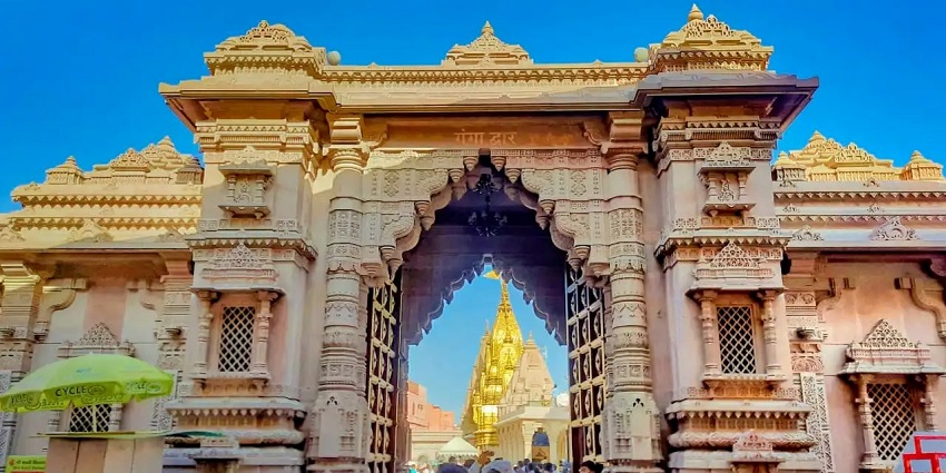 View of the striking gates of the beautiful Ganga Mandir with people during the day.